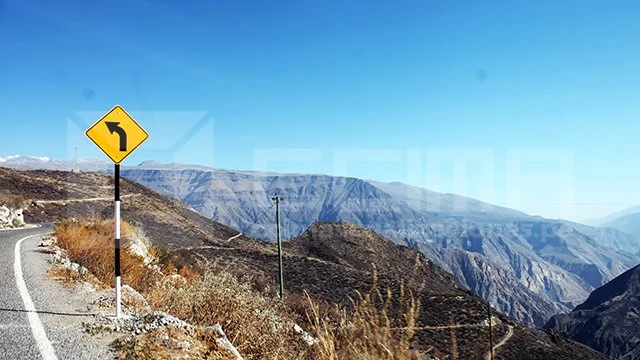 Conductor respetando la señal de Tránsito Pesado a la Derecha en una carretera de Arequipa con paisaje de montaña